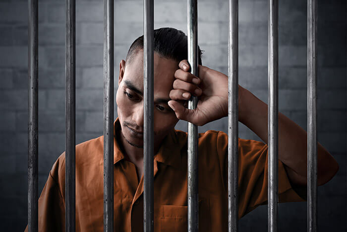 man behind bars in jail